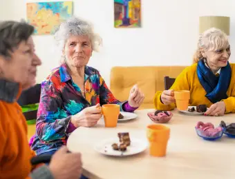 a group of women enjoying a meal in the memory care unit