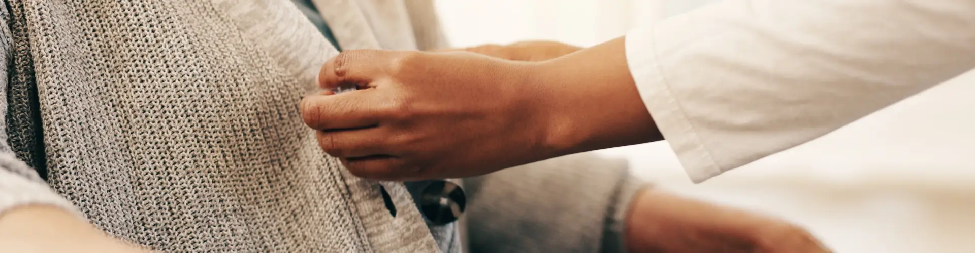 hands buttoning a sweater