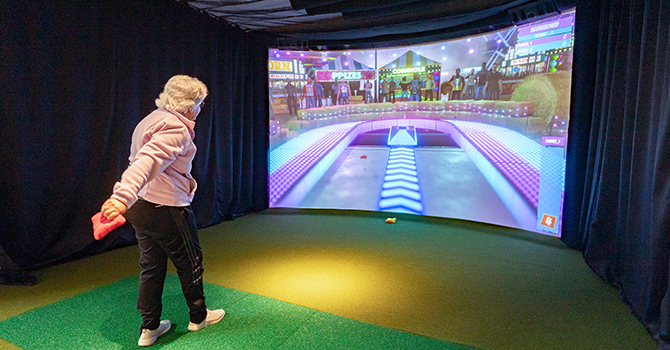 client playing virtual cornhole